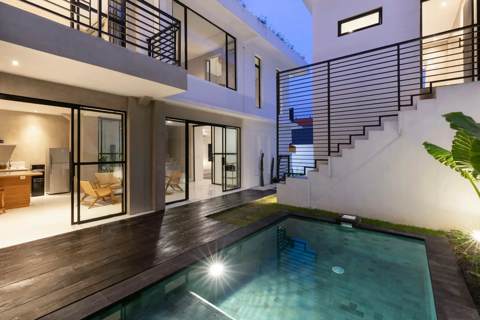 Pool with a wood deck and the lower-level terrace of a house