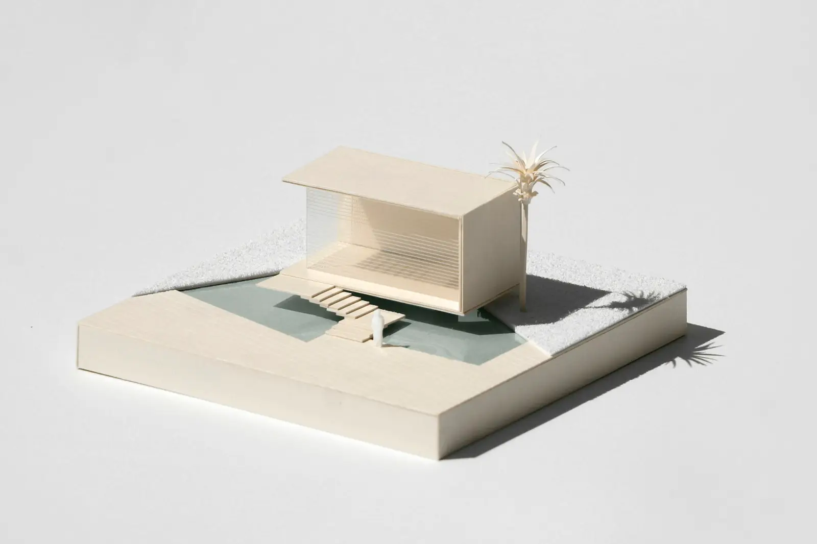 White paper model of a house standing on a water surface