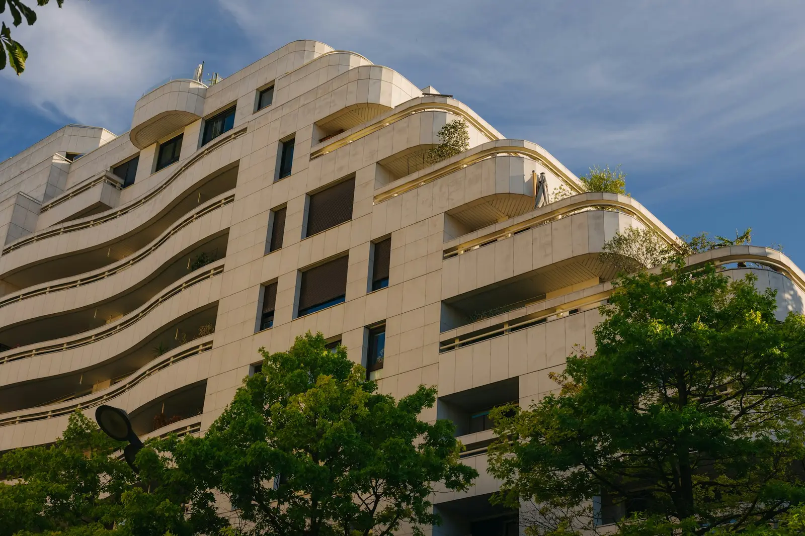 Cream apartment building facade with wavy balcony lines