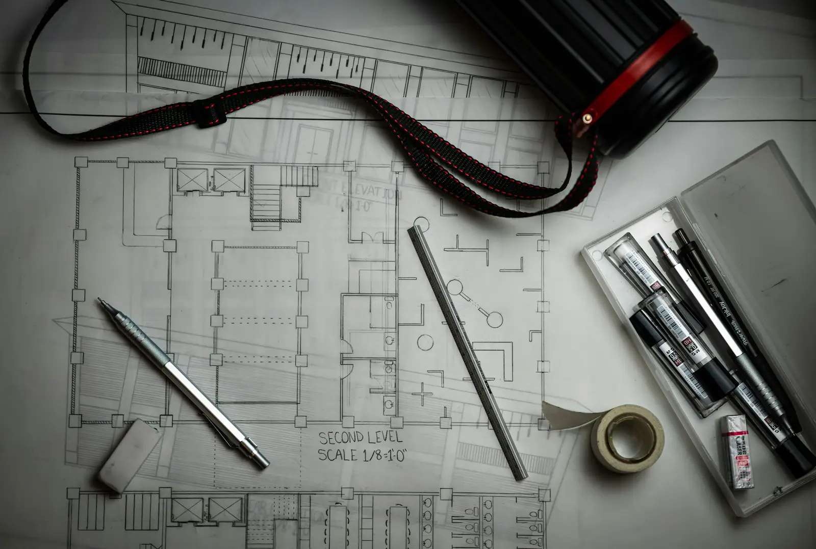 Desk with plan drawings, a pencil and drafting tools